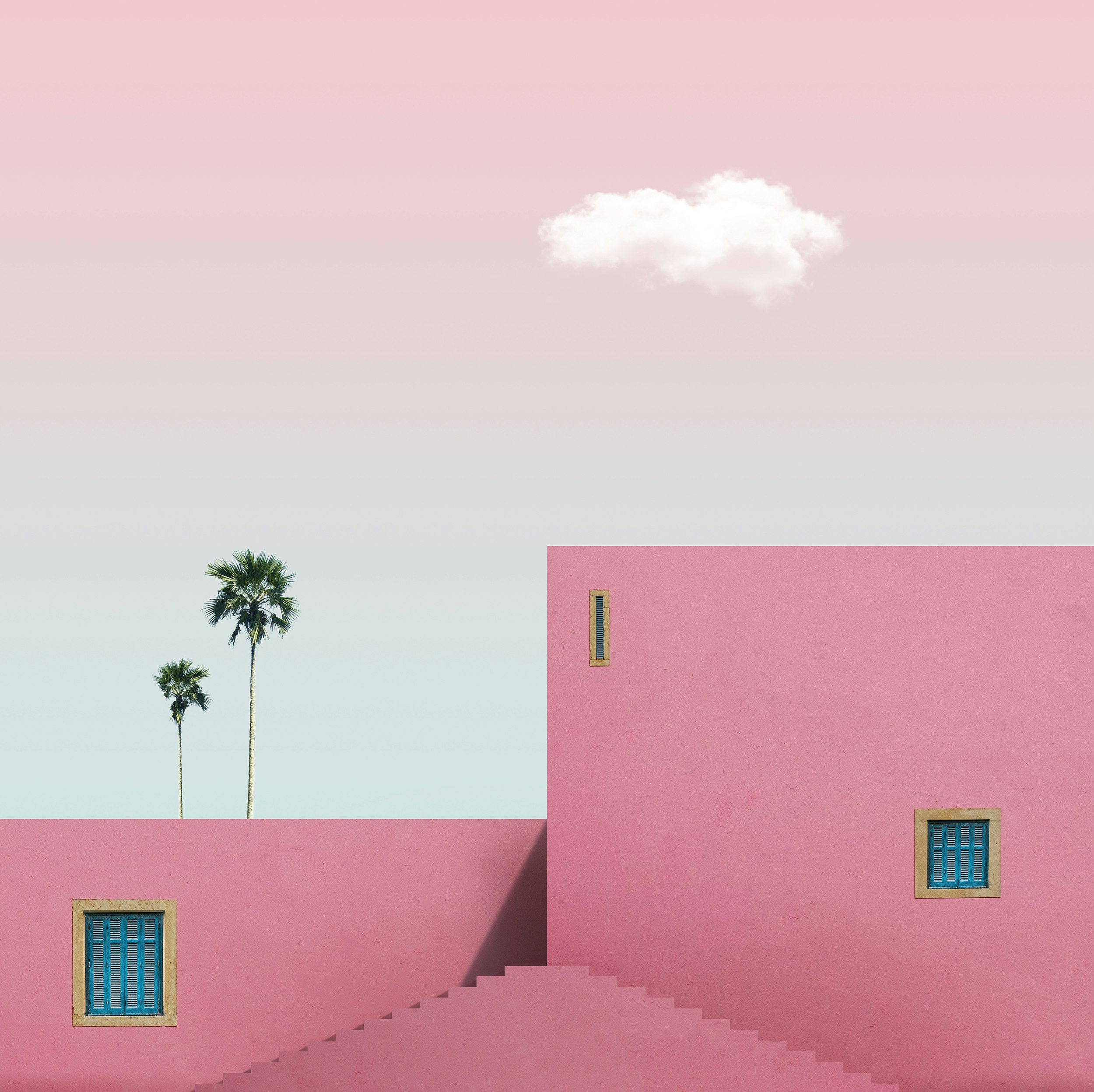 pink concrete building with palm tree in front